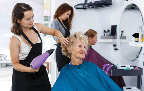 A woman is getting her hair styled by another woman in a salon. AI generated content