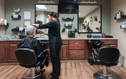 A woman is getting her hair styled by another woman in a salon. AI generated content