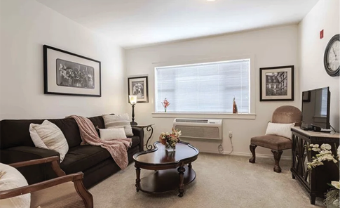 A living room with a couch, chair, coffee table, and television. The room is decorated with pictures and a clock on the wall. AI generated content