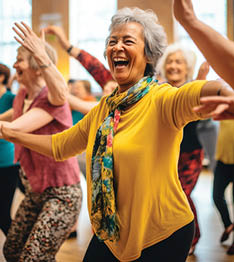 A woman wearing a yellow shirt and a scarf is laughing and dancing with other women in a room. AI generated content